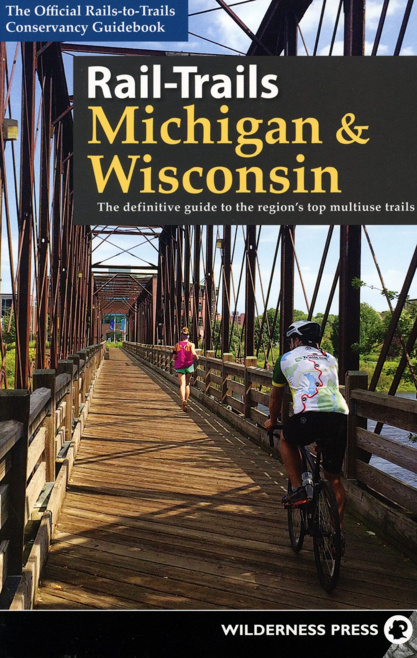 Cyclists on a scenic rail-trail bridge.