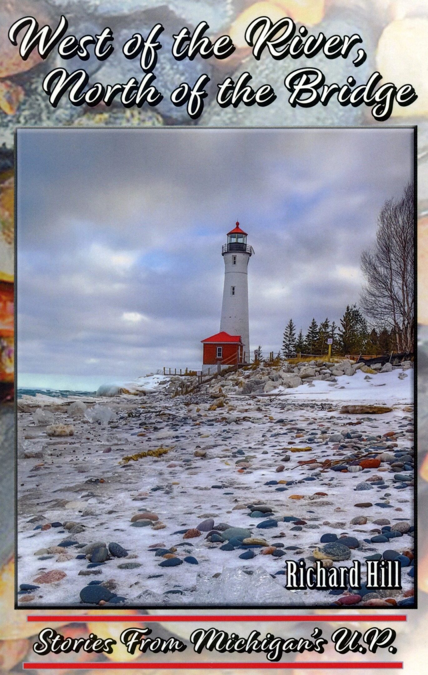 Lighthouse on rocky shoreline under cloudy sky.