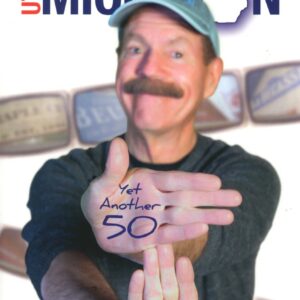 Man posing with hand-written messages, smiling.