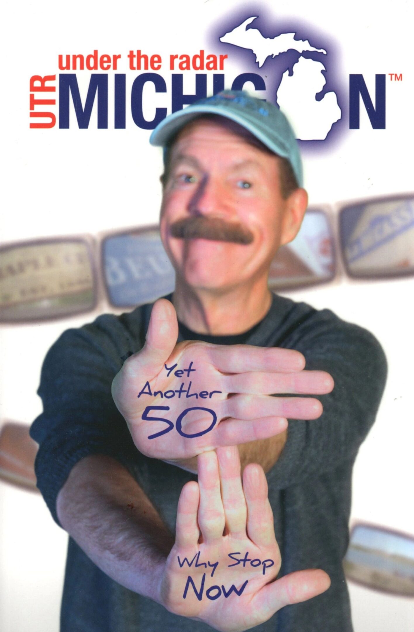 Man posing with hand-written messages, smiling.